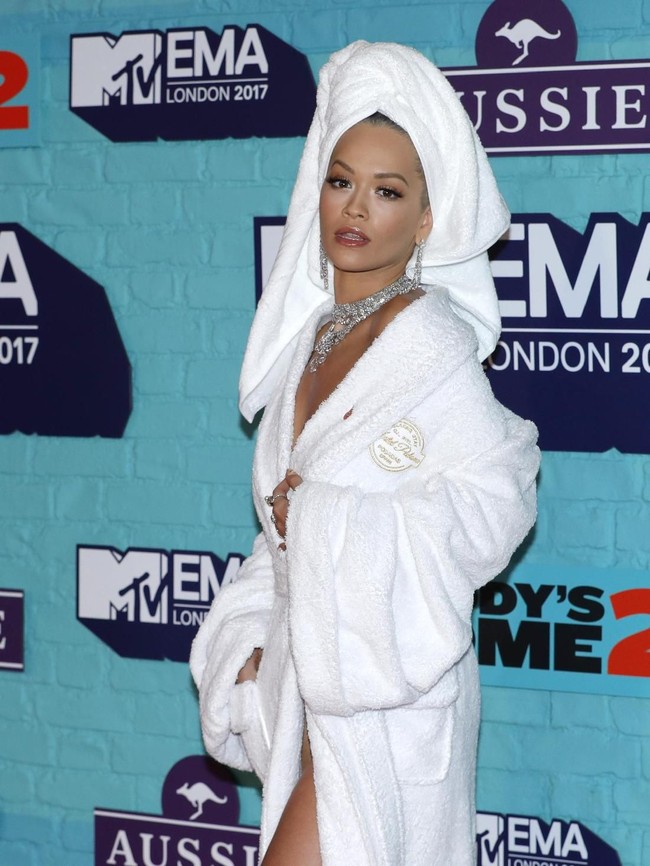 Meskipun hanya pakai handuk dan jubah mandi, makeup Rita Ora tetap on point dengan eye shadow merah bata dan lipstik berkilau. Foto: Getty Images