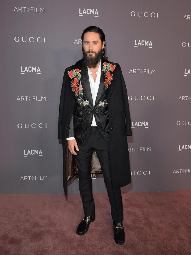 Setelan Gucci lagi-lagi menjadi pilihan Jared Leto untuk LACMA Art + Film Gala di Los Angeles, AS. Namun kali ini setelan serba hitam yang dipadu dengan coat bermotif floral. (Foto: Getty Images)