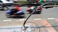 Motor melintas disamping kabel yang menguntai hingga kebawah di bilangan Mayestik, Jakarta. 
