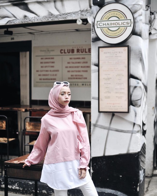 Joyagh memakai atasan dengan warna millenial pink yang memiliki aksen ruffle di pundak. Ia sengaja memadukan atasan polos tersebut dengan kerudung warna serupa agar tetap matching dan feminin. Warna millenial pink ini memang memberikan sentuhan yang cocok untuk wanita feminin. Foto: Dok. Instagram