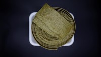 Kalau ini namanya Injogigi. Bentuknya lembaran bertekstur yang dibuat dari protein sayuran. Jajanan ini bisa didapat dari penjual makanan ilegal maupun dari pemerintah Korea Utara. Foto: Reuters