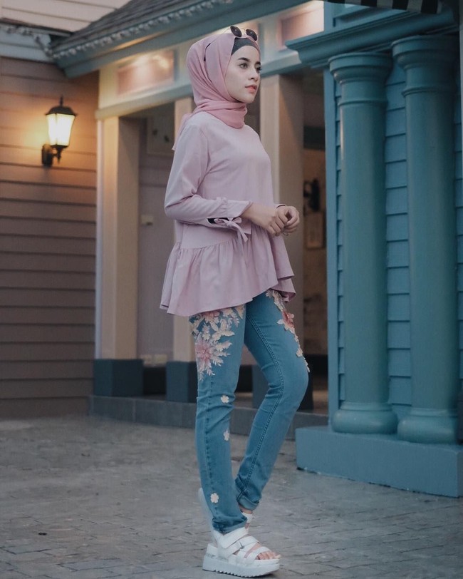 Aghnia Punjabi bergaya ddengan celana jeans dan ruffle top millenial pink tanpa corak. Ia tampak kasual dengan padu padan sneakers dan scarf panjang bahan sifon. Foto: Dok. Instagram
