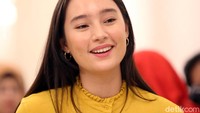 Ia tampil menawan dengan busana berwarna kuning.