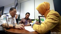 Direktur Distribution Bank Mandiri Hery Gunardi (tengah) dan Sekretaris Jenderal Kementerian Perhubungan Sugihardjo (kiri) menyerahkan buku tabungan usai meresmikan pengoperasian kantor cabang di Kementerian Perhubungan, Jakarta.