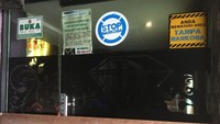 Pintu masuk ditutup oleh triplek. Seluruh karyawan yang lain diliburkan karena tutup.