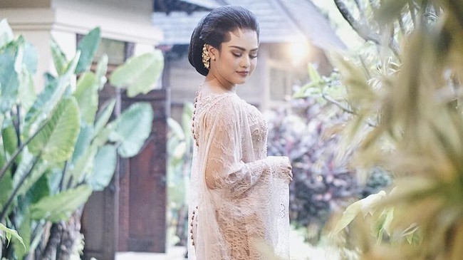 Penyanyi Mytha Lestari memakai kebaya brokat bernuansa nude di malam Midodareni. Tampilan kebaya terasa lebih anggun dengan ornamen lengan menyerupai cape. Foto: Dok. Instagram