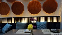 Sofa dengan sandaran kayu berwarna biru makin membuat suasana hangat. Untuk menambah kesan berwarna, di mejanya juga dihias dengan bunga cantik. Foto: Lusiana Mustinda