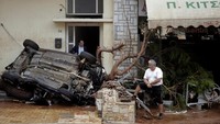 Beberapa warga terpaksa naik ke balkon dan atap rumah untuk menghindari banjir. Foto: REUTERS/Alkis Konstantinidis