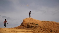 Seorang anak sedang bermain layang-layang dekat tempat penampungan sementara kaum Rohingya.