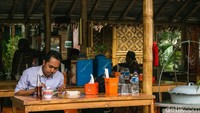 Seorang pengunjung sedang menikmati laksa.