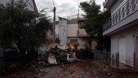 Warga setempat terbangun disambut hujan deras dan air lumpur masuk ke rumah-rumah mereka. Foto: AFP PHOTO/Angelos Tzortzinis