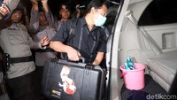 Para penyidik memasukkan koper-koper itu ke dalam mobil.