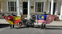 Pasangan ini mengibarkan bendera Malaysia sesampai London (Mohd Alfishahrin/Facebook)
