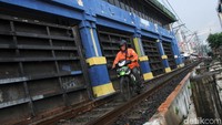 Demi mempersingkat waktu tempuh, para pengendara motor ini rela melintasi rel kereta api tersebut.