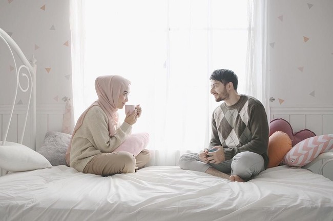Foto selebgram Hamidah Rachmayanti dan Irvan Farhad juga bisa menjadi inspirasi foto prewedding tak bersentuhan untuk hijabers. Keduanya tampak menikmati kebersamaan ketika berada di atas tempat tidur dan duduk dengan ada jarak. Foto: Dok. Instagram