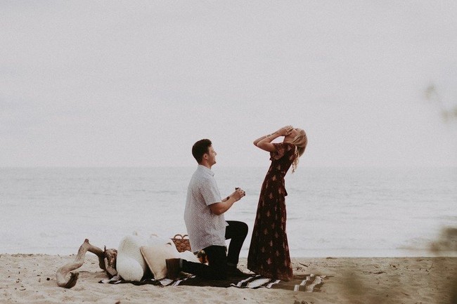 Membuat piknik di tepi pantai dan mempersembahkan momen spesial dengan melamar kekasih, siapa yang bisa menolak? Foto: Dok. Brides.com
