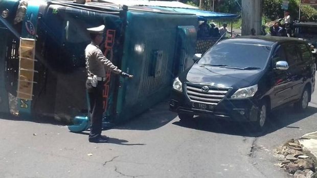 Polisi mengatur lalu lintas karena bus menutup separuh jalan