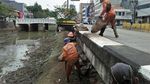 Potret Pasukan Oranye di Hitamnya Lumpur Kali di Jl Gajah Mada