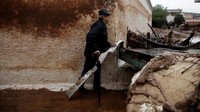 Seseorang membersihkan debris sisa-sisa banjir di Yunani. Foto: Alkis Konstantinidis/Reuters