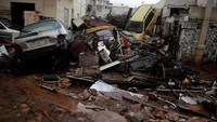 Mobil hingga debris menyangkut di rumah warga belum dibersihkan. Foto: Alkis Konstantinidis/Reuters