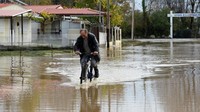 Seseorang menerobos banjir di Desa Variko. Foto: Alexandros Avramidis/Reuters