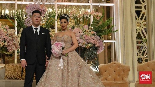 Penampilan Dwina Michaella di hari pernikahannya bak putri raja. Dia tampil dengan gaun megah berdetail bebatuan kristal. Dia juga melengkapi penampilannya dengan kalung dan tiara yang berkilauan. Foto: Dok. CNN Indonesia