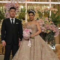 Penampilan Dwina Michaella di hari pernikahannya bak putri raja. Dia tampil dengan gaun megah berdetail bebatuan kristal. Dia juga melengkapi penampilannya dengan kalung dan tiara yang berkilauan. Foto: Dok. CNN Indonesia