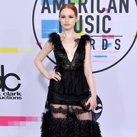 Madeleine Petsch tampil klasik nan timeless dengan riasan rambut sleek dan makeup yang fokus pada mata. Meski penampilannya tampak klasik, namun gaun sheer dengan aplikasi bordir dan bulu terasa modern. Foto: Dok. Getty Images