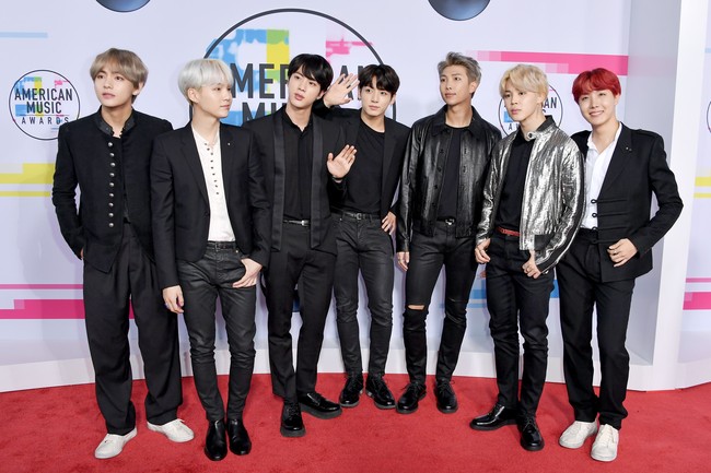 Rap Monstar terlihat tampil dengan jaket kulit berkancing. Suga memilih jas hitam dengan lapel minimalis yang dipadukan dengan atasan putih. J-Hope dan V tampil unik dengan jas ala cheongsam.Foto: Getty Images