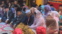Kahiyang dan Bobby duduk bersila bersama keluarga.