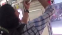 Pria ini menarik ular dari rak bagasi di dalam KRL. Ia terlihat tidak takut saat menarik ular itu.