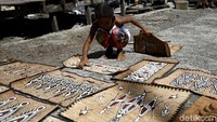 Beberapa warga sibuk menjemur sejumlah lukisan kulit kayu di bawah terik matahari.