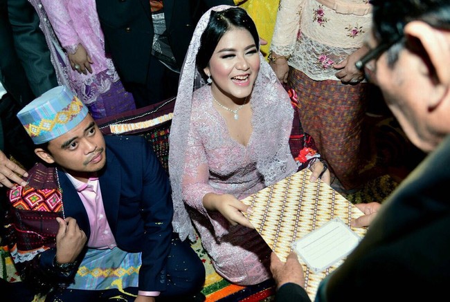 Warna kebaya Kahiyang juga tampak berpadu manis dengan kemeja Bobby yang dibungkus jas hitam. Bobby turut melengkapi gayanya dengan sarung dan peci abu-abu bermotif sama. Foto: Media Center Kahiyang-Bobby