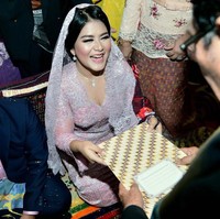 Warna kebaya Kahiyang juga tampak berpadu manis dengan kemeja Bobby yang dibungkus jas hitam. Bobby turut melengkapi gayanya dengan sarung dan peci abu-abu bermotif sama. Foto: Media Center Kahiyang-Bobby