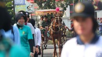 Keduanya ikut dalam rombongan peserta dengan menaiki delman yang rencana akan membawa rombongan Presiden Jokowi.