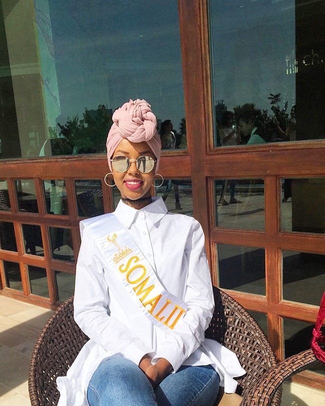 Sementara pada penampilannya lainnya, masih semasa karantina Miss Global 2017, Ayan Said memakai setelan celana jeans dan kemeja asimetris warna putih. Gaya turban dengan pashmina pink yang dibuat lilitan pada bagian depannya memberikan kesan eksentrik. Foto: Dok. Instagram @iamayansaid