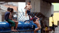 Tanpa rasa takut, sejumlah anak itu bermain dan berenang di sungai yang terletak di Jakarta Timur tersebut.