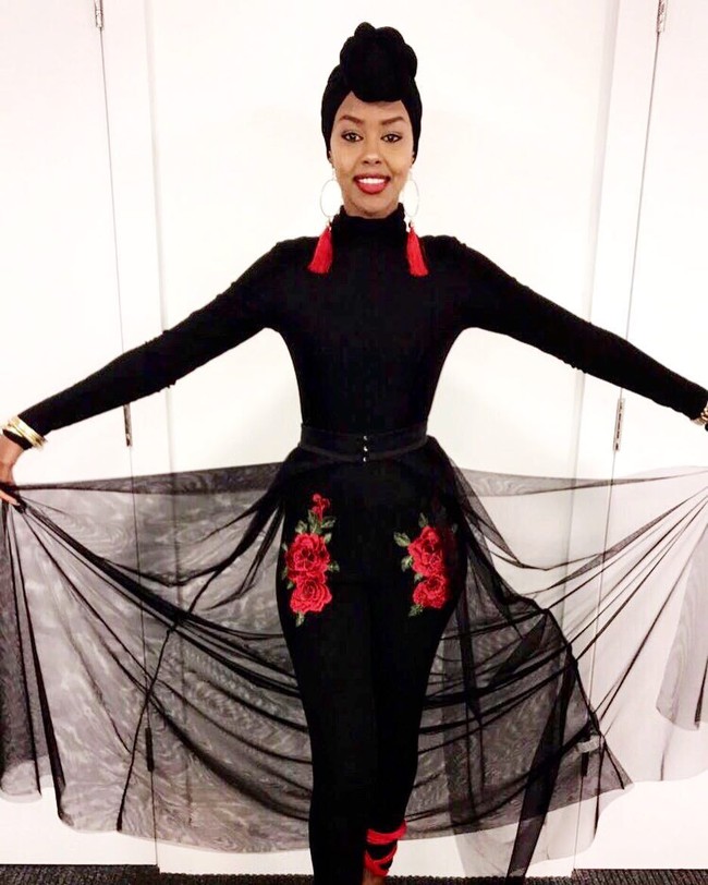 Ayan Said memakai setelan serba hitam dengan sentuhan bordir bunga merah pada celananya sehingga terlihat dramatis. Gayanya terlihat eksentrik dengan tambahan anting bulat yang memiliki tassel dan jilbab turban.  Foto: Dok. Instagram @iamayansaid