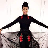 Ayan Said memakai setelan serba hitam dengan sentuhan bordir bunga merah pada celananya sehingga terlihat dramatis. Gayanya terlihat eksentrik dengan tambahan anting bulat yang memiliki tassel dan jilbab turban.  Foto: Dok. Instagram @iamayansaid