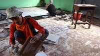 Pekerja tengah memasang keramik di sebuah kelas SDN Cawang 04, Jakarta Timur.