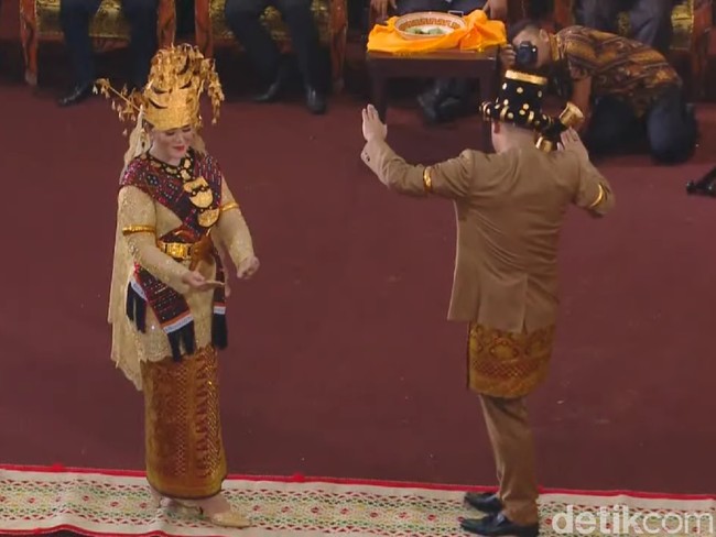 Malam harinya, Kahiyang memakai baju kurung emas buatan Bu Mojo lengkap dengan hiasan kepala pengantin Mandailing bernama bulang. Foto: Dok. CNN Indonesia TV
