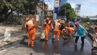 Pekerja Penanganan Sarana dan Prasarana Umum (PPSU) dibantu warga sekitar tampak membersihkan lokasi kebakaran. Jalur lambat pun ditutup sementara.Fotografer: Arief Ikhsanudin/detikcom