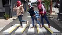 Beberapa warga memanfaatkan lukisan tersebut untuk berfoto.