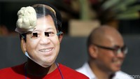 Massa memakai topeng Setya Novanto yang ditempeli bakpao di kepalanya.