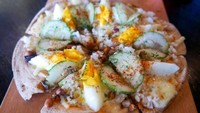 Kafe Brulee Brasserie membuat pizza dengan topping bahan-bahan nasi lemak. Ada keju, kacang tanah, ikan teri, telur rebus hingga mentimun dengan paduan bubuk cabai. Enak nggak ya? Foto: Istimewa