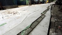 Cor-coran jalan masih ditutup dengan plastik dan belum bisa dilintasi.