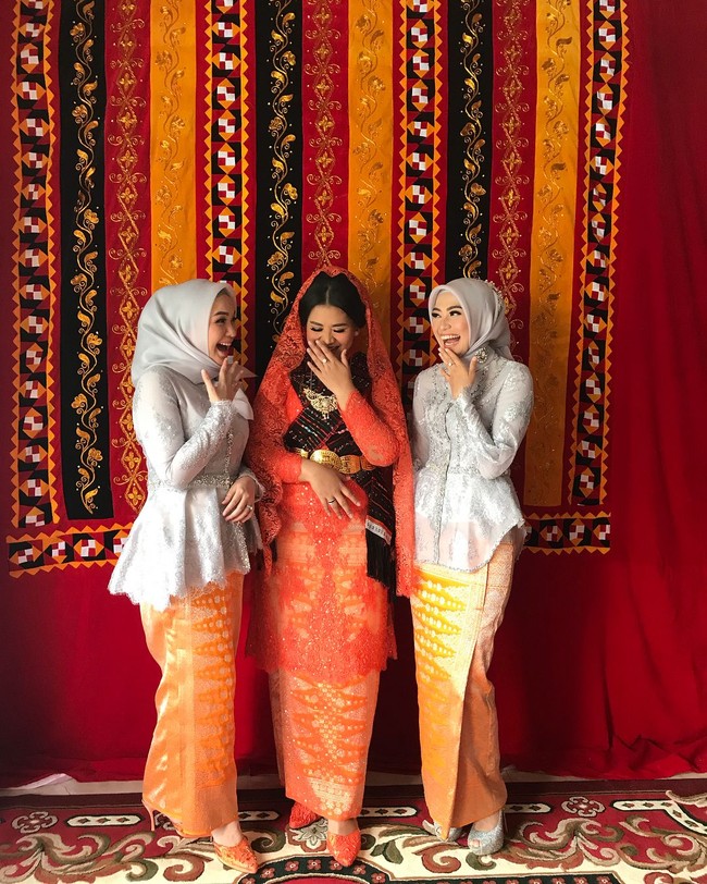 Candid atau plandid (plan-candid)? Berlatar ulos khas Mandailing, ketiga wanita kesayangan Bobby difoto sambil tertawa di sela sesi manortor, Sabtu (25/11/2017). Foto: Instagram