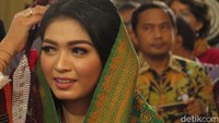 Dia juga dipakaikan kerudung warna hijau.