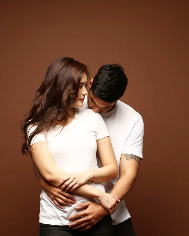 Foto prewedding romantis dan intim lainnya ditunjukkan Marcel Chandrawinata dan Deasy Priscilla dengan memakai baju kembar yang kasual. Dengan mengenakan kaos putih, Marcel memeluk dan mencium pundak Deasy dari belakang. Foto: Dok. Instagram