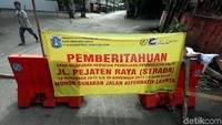 Spanduk pemberitahuan penutupan terpampang di jalan tersebut.